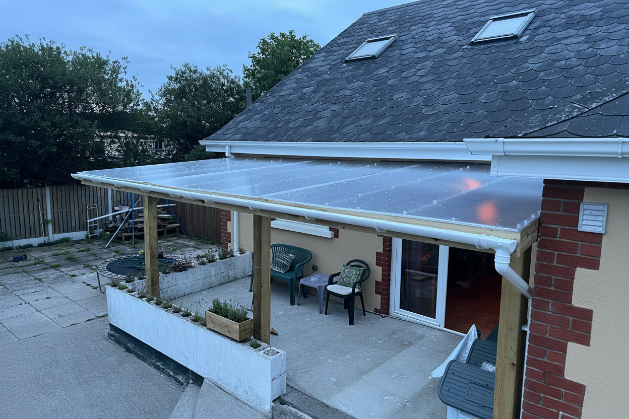 Clear polycarbonate roofing sheets installed on timber lean-to patio cover
attached to Irish home — DIY canopy with wooden posts and aluminium guttering